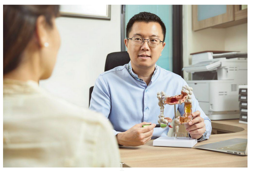Dr Mark Wong, spesialis bedah berpengalaman di Singapura, menjelaskan penanganan ambeien kepada pasien.